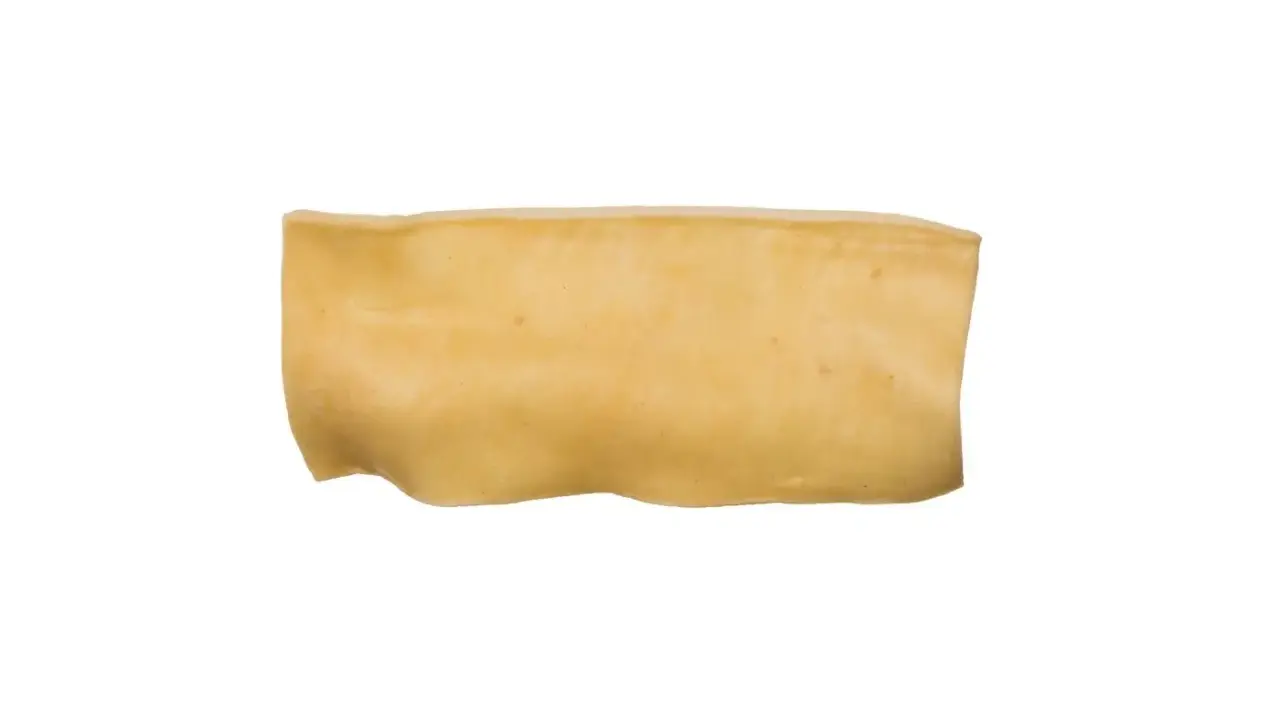 En bit ljusgul, böjd tuggpinne för hundar, liknande en tjock rauh älgchips.