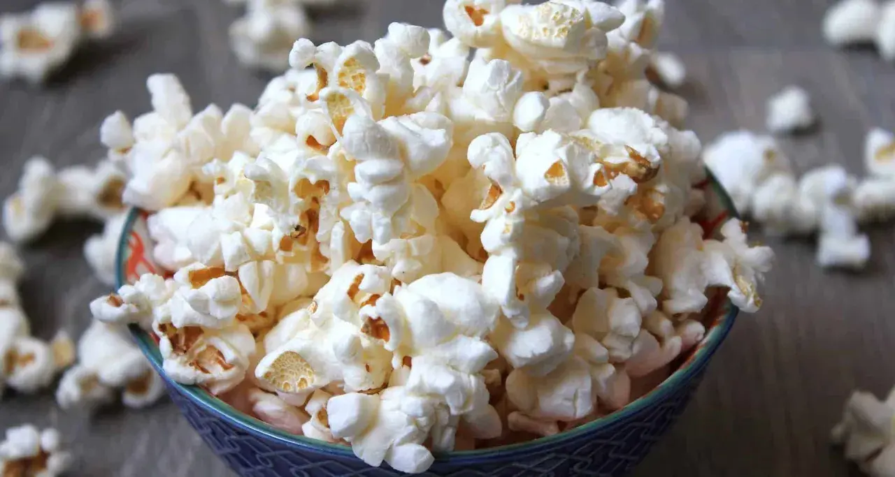 En skål med fluffig popcorn, perfekt för en mysig filmkväll. En popcorn hund skulle älska detta!