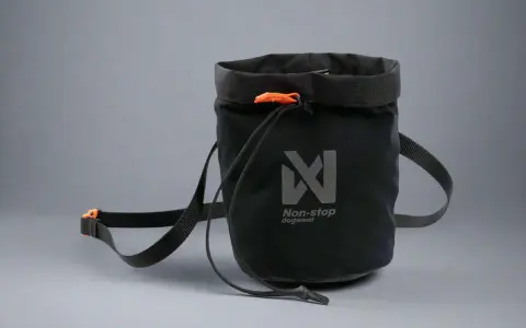 Svart belöningsväska hund med orange detaljer och Non-stop dogwear-logga. Perfekt för träning och promenader.