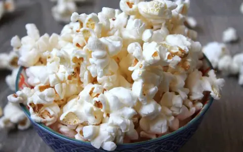 En skål med fluffig popcorn, perfekt för en mysig filmkväll. En popcorn hund skulle älska detta!