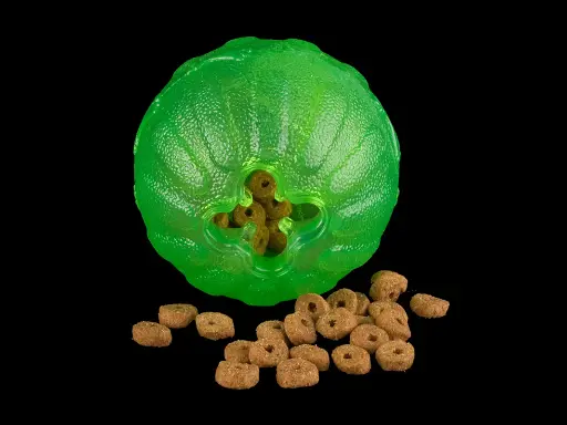 En grön, knottrig leksak med hål där hundgodis sticker ut. En hög med hundgodis ligger framför. En riktig funball för din hund!