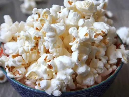 En skål med fluffig popcorn, perfekt för en mysig filmkväll. En popcorn hund skulle älska detta!