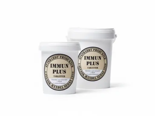 Två vita burkar med etiketter för "Immun Plus Tabletter" från Standardt Produkter. En burk är mindre och står framför en större.