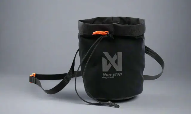 Svart belöningsväska hund med orange detaljer och Non-stop dogwear-logga. Perfekt för träning och promenader.