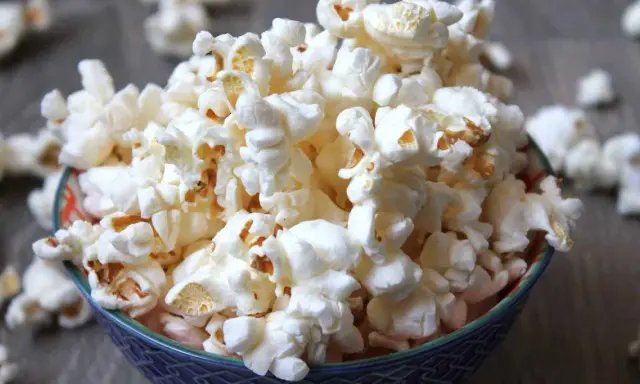 En skål med fluffig popcorn, perfekt för en mysig filmkväll. En popcorn hund skulle älska detta!