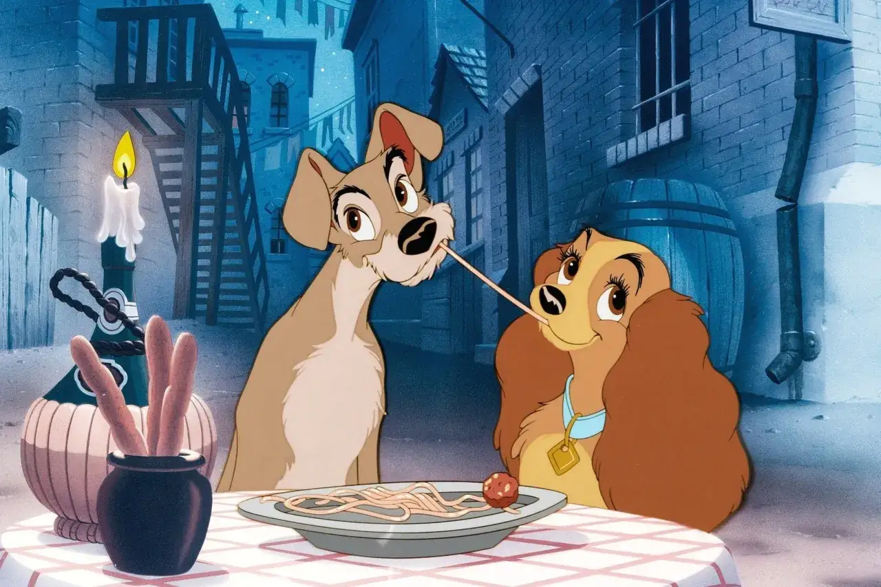 Lady och Lufsen delar en romantisk spaghetti-middag under en stearinljus.